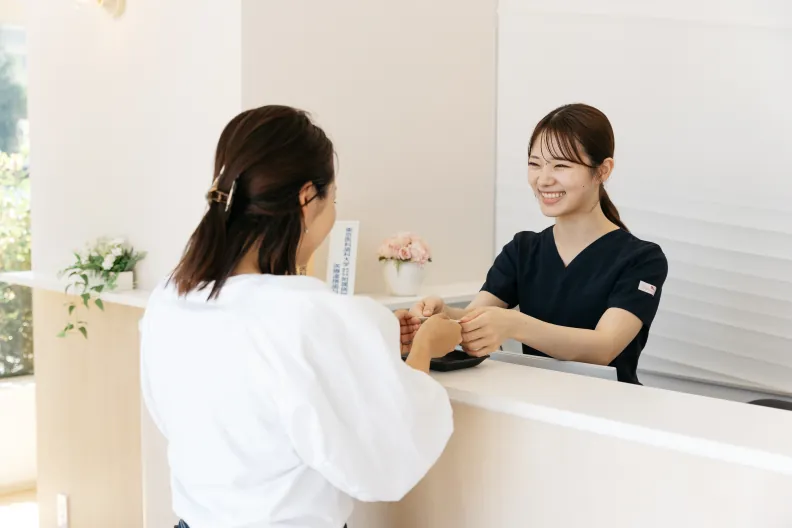 受付で患者さんを笑顔で迎えるスタッフ