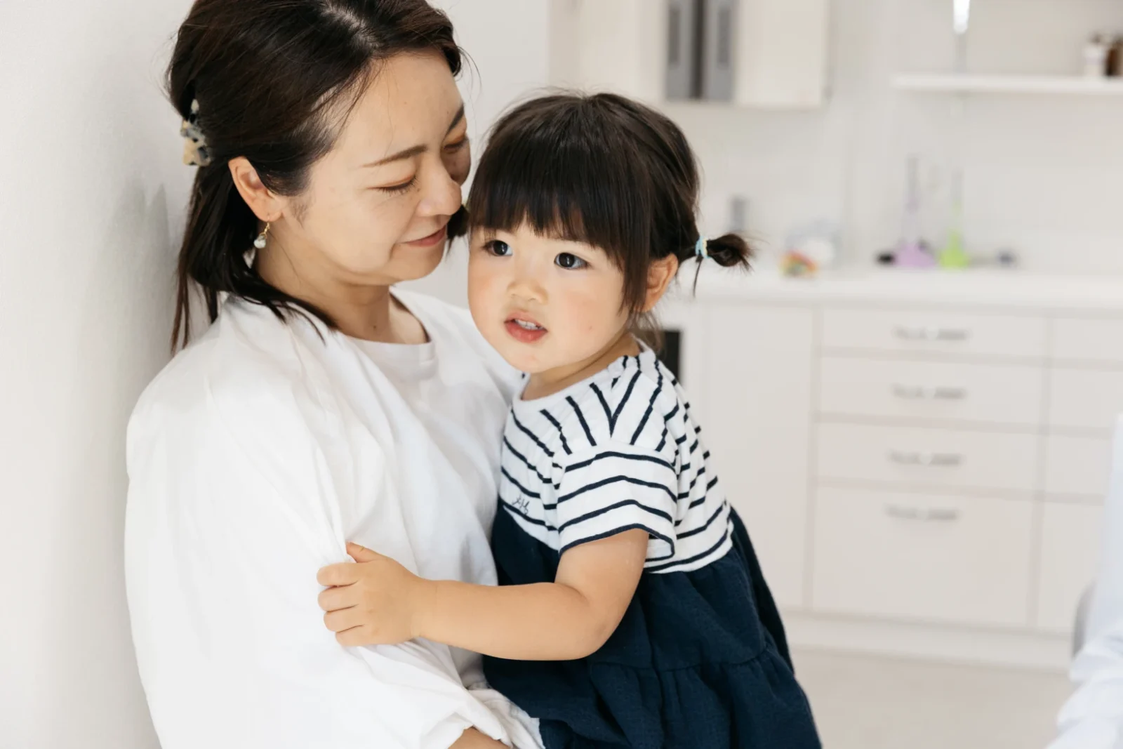お子さまを抱く保護者