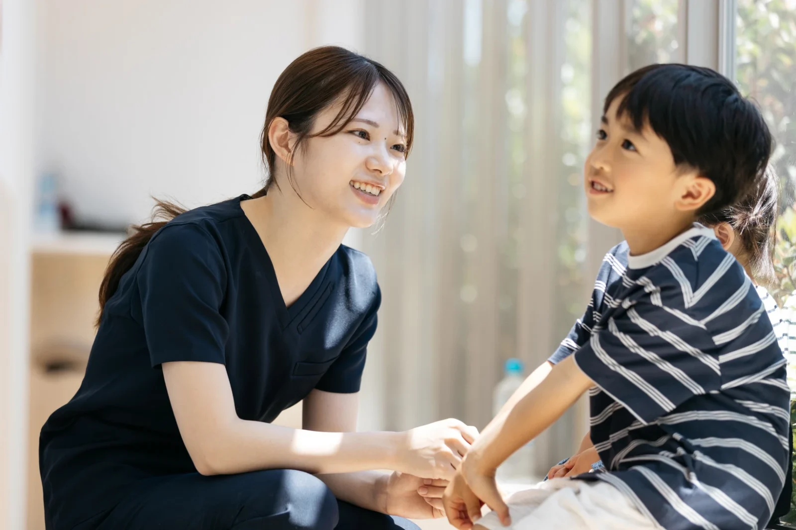 お子さまと会話する歯科スタッフ