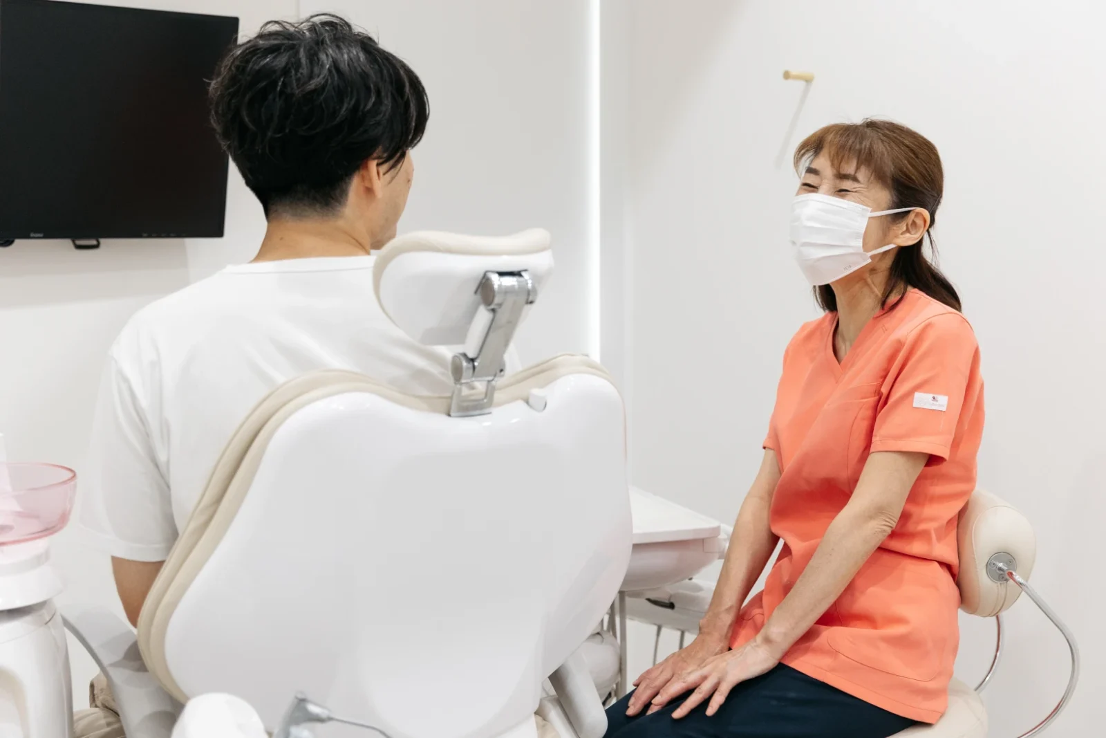 診療室で患者に説明する歯科スタッフ